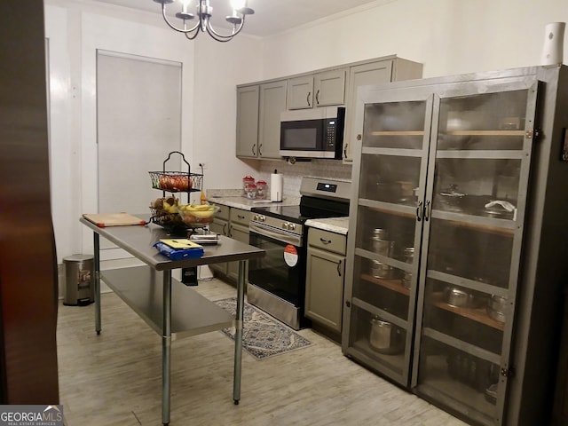 kitchen featuring an inviting chandelier, appliances with stainless steel finishes, decorative light fixtures, and light hardwood / wood-style flooring