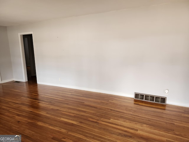 empty room with dark hardwood / wood-style flooring