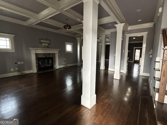 unfurnished living room with crown molding, a premium fireplace, coffered ceiling, dark hardwood / wood-style flooring, and ornate columns