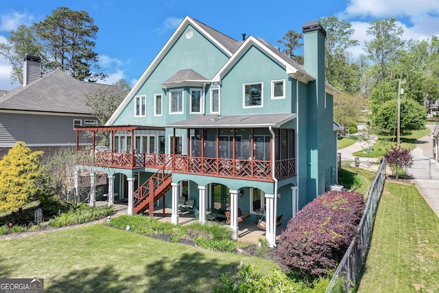 6780 Lawson Cir, Gainesville, GA 30506 - back of house with a chimney, a sunroom, a yard, and stucco siding