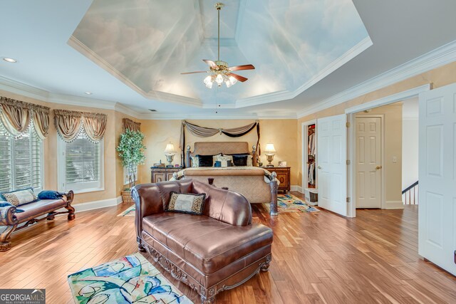 6780 Lawson Cir, Gainesville, GA 30506 - bedroom with baseboards, crown molding, a tray ceiling, and light wood-type flooring