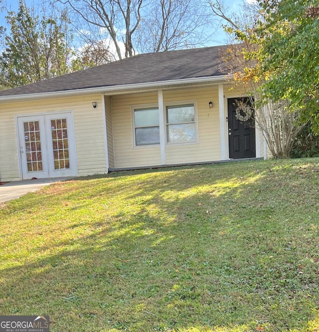 view of front facade with french doors and a front lawn