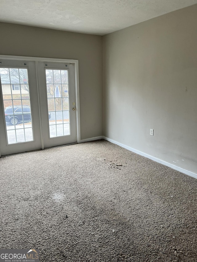 carpeted spare room featuring a textured ceiling