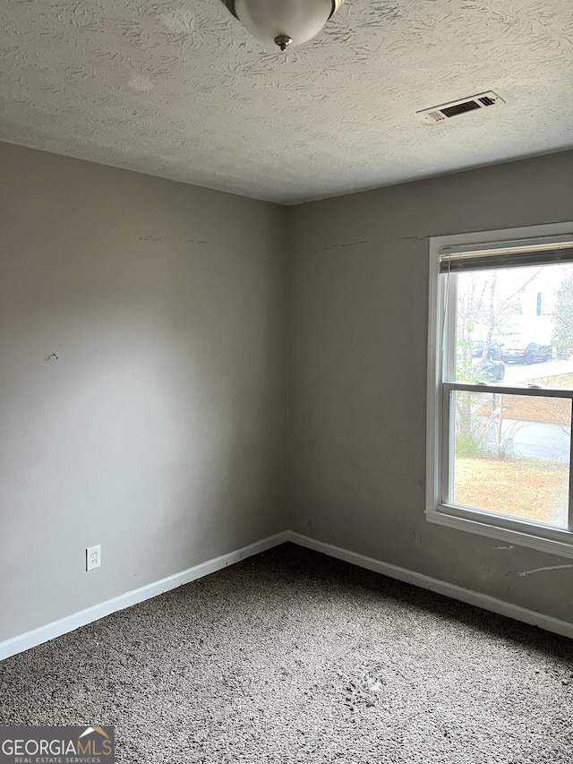 carpeted spare room featuring a textured ceiling