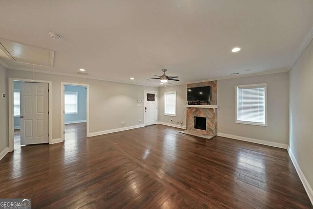 unfurnished living room with ornamental molding, dark wood-type flooring, ceiling fan, and a high end fireplace