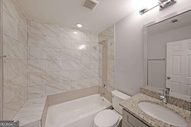 full bathroom featuring tiled shower / bath combo, vanity, and toilet