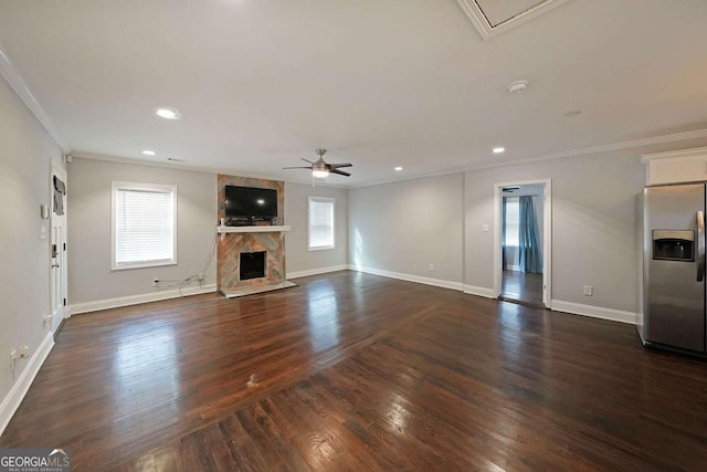 unfurnished living room with dark hardwood / wood-style flooring, ornamental molding, ceiling fan, and a fireplace