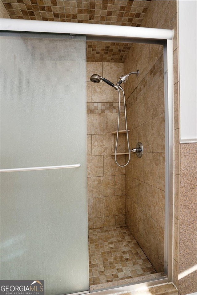 bathroom with a shower with door