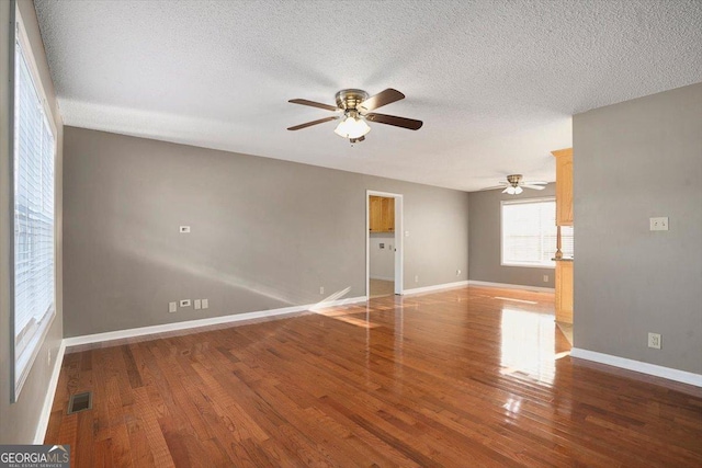 unfurnished room featuring ceiling fan, wood-type flooring, and a textured ceiling