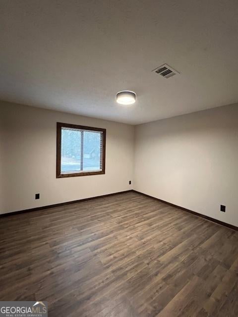 spare room with dark hardwood / wood-style floors