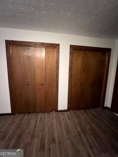 unfurnished bedroom featuring dark hardwood / wood-style flooring, a closet, and a textured ceiling