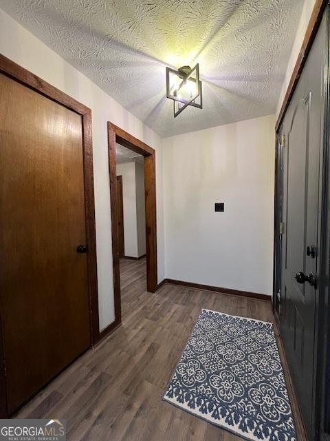 hall featuring wood-type flooring and a textured ceiling