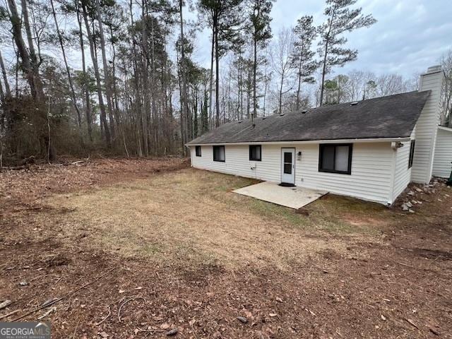 rear view of house featuring a patio and a lawn