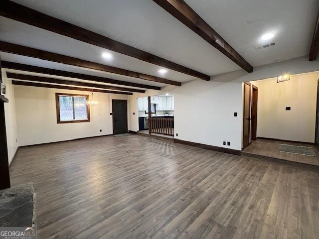 unfurnished living room featuring dark hardwood / wood-style flooring and beam ceiling