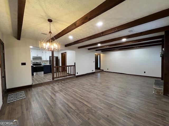 unfurnished living room featuring dark hardwood / wood-style flooring, a chandelier, beam ceiling, and a textured ceiling