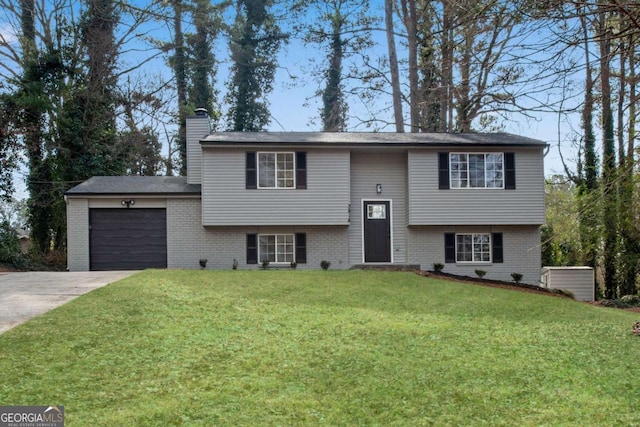 bi-level home featuring a garage and a front lawn