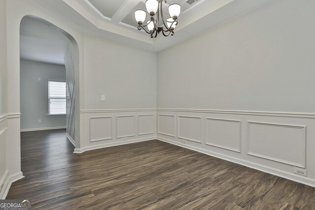 spare room featuring arched walkways, visible vents, an inviting chandelier, dark wood finished floors, and crown molding