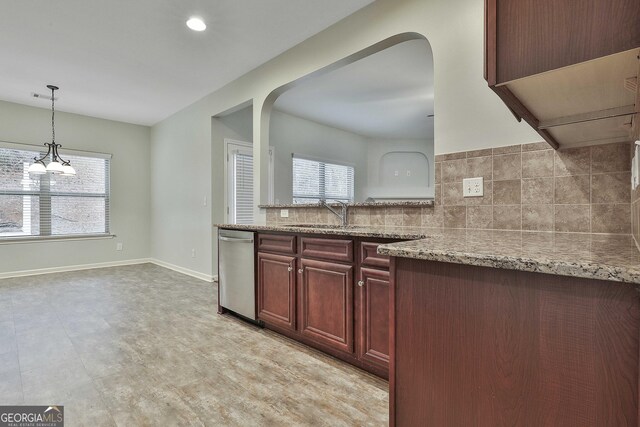 kitchen with tasteful backsplash, baseboards, light stone counters, dark brown cabinets, and stainless steel dishwasher