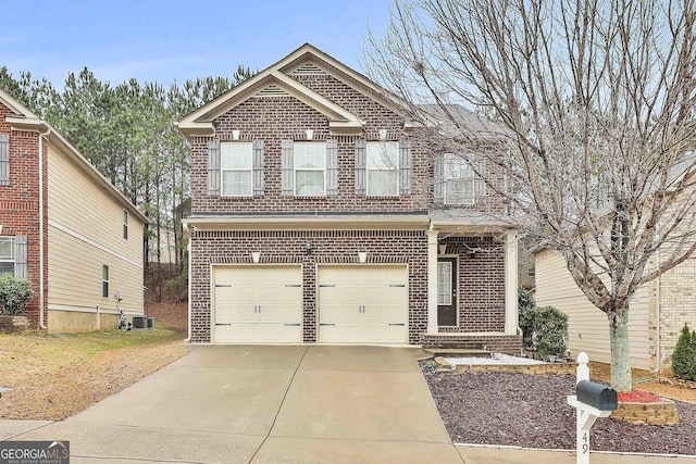 traditional-style home with concrete driveway, brick siding, an attached garage, and central AC unit