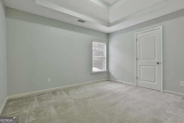 unfurnished room featuring baseboards, visible vents, and light colored carpet