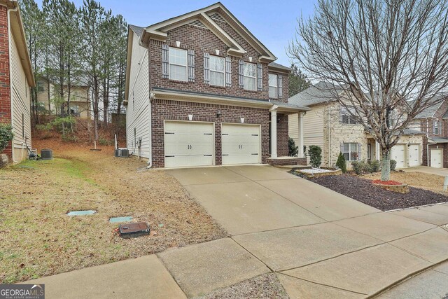 view of front of home with an attached garage, central AC unit, concrete driveway, and brick siding