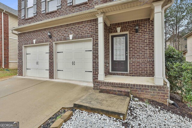 doorway to property with brick siding and driveway