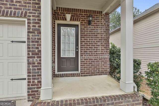 doorway to property featuring brick siding