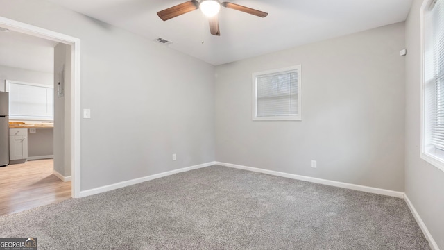 unfurnished room with ceiling fan and carpet