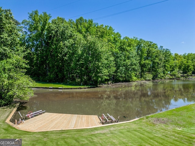 view of dock featuring a water view and a yard