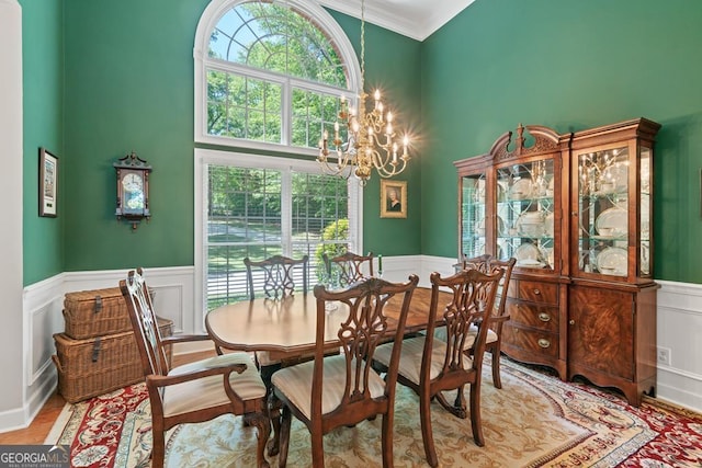 dining space with an inviting chandelier, a towering ceiling, and wood-type flooring