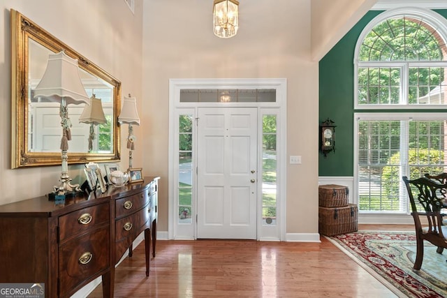 entrance foyer featuring a high ceiling, a notable chandelier, and light hardwood / wood-style floors