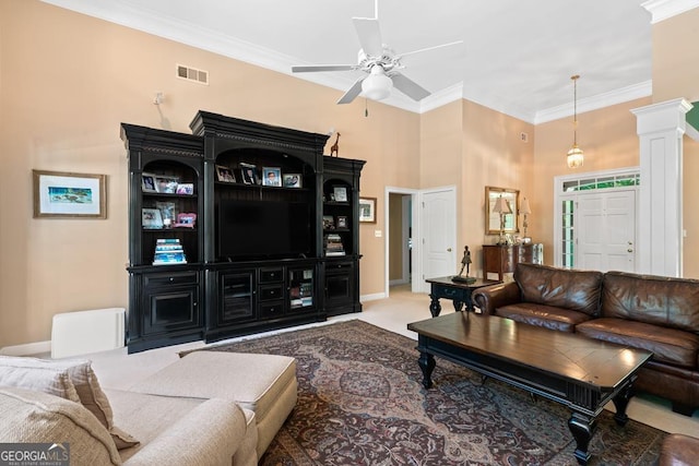 living room featuring decorative columns, ornamental molding, carpet flooring, and ceiling fan