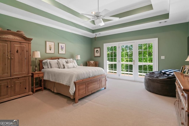 carpeted bedroom featuring crown molding, access to exterior, ceiling fan, and a tray ceiling