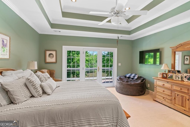 bedroom featuring a raised ceiling, ornamental molding, light carpet, and access to exterior