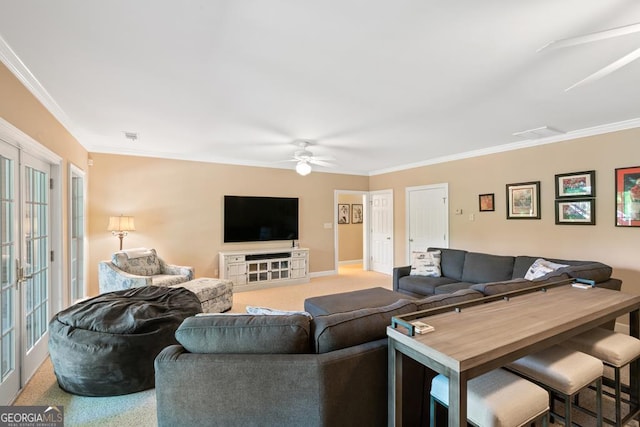 carpeted living room featuring ornamental molding, french doors, and ceiling fan