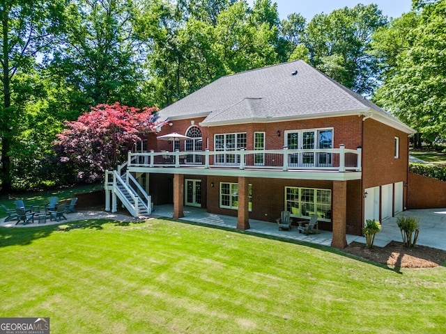 back of property with a wooden deck, a garage, a patio area, and a lawn