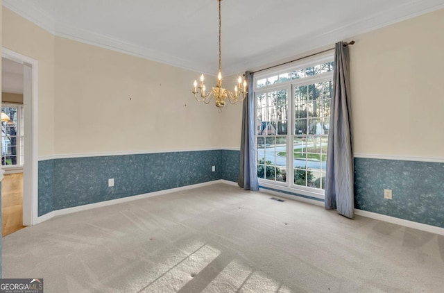 carpeted empty room with a notable chandelier, plenty of natural light, and ornamental molding