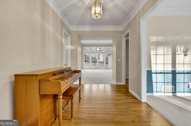 hallway featuring ornamental molding and hardwood / wood-style floors