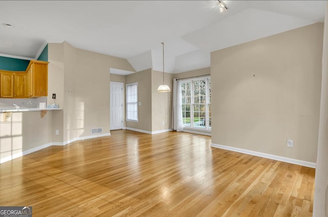 unfurnished living room with lofted ceiling and light hardwood / wood-style flooring