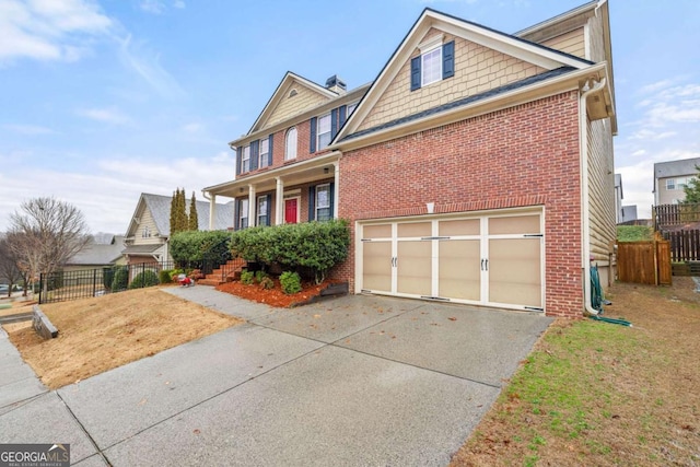 view of front of house with a garage, driveway, brick siding, and fence