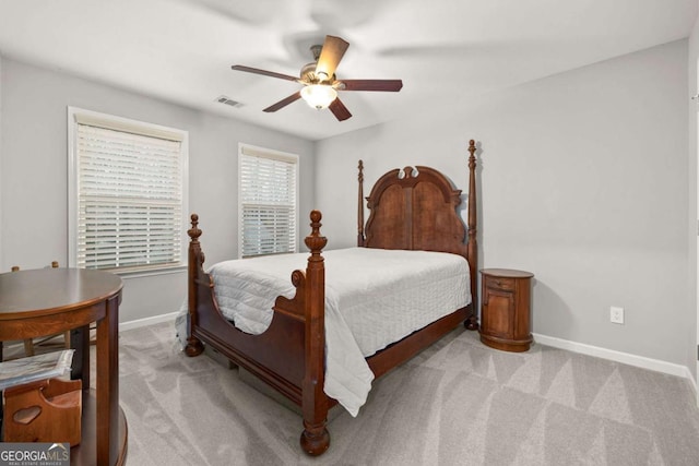 bedroom with baseboards, a ceiling fan, visible vents, and light colored carpet