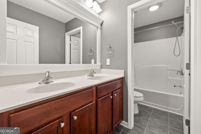 bathroom with washtub / shower combination, a sink, toilet, and tile patterned floors