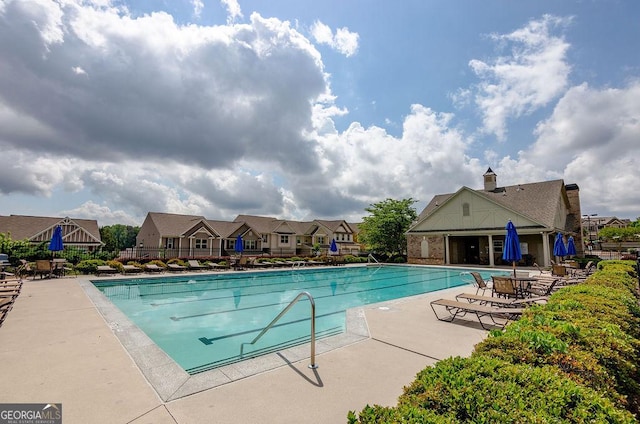 pool featuring a patio area, fence, and a residential view