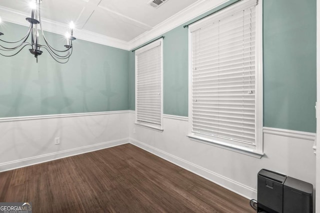 unfurnished dining area with a notable chandelier, baseboards, wainscoting, dark wood finished floors, and crown molding