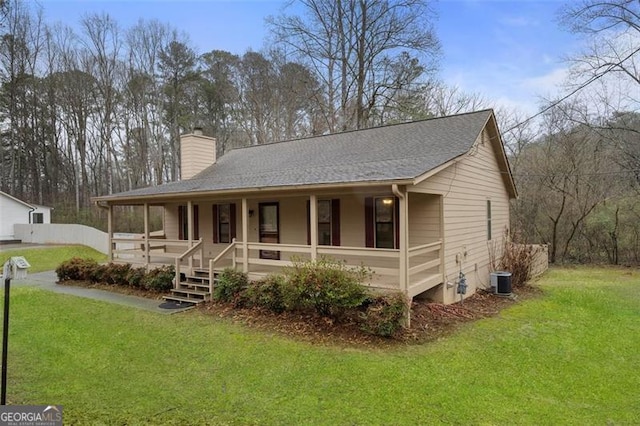 view of front facade featuring a porch, central AC unit, and a front lawn