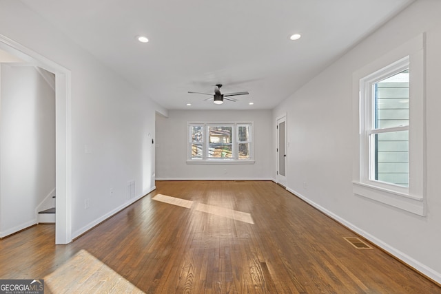 unfurnished living room featuring dark wood-type flooring and ceiling fan