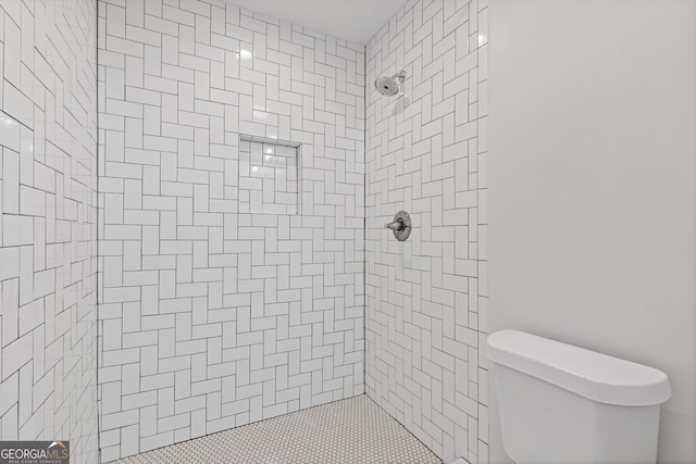 bathroom with toilet and tiled shower