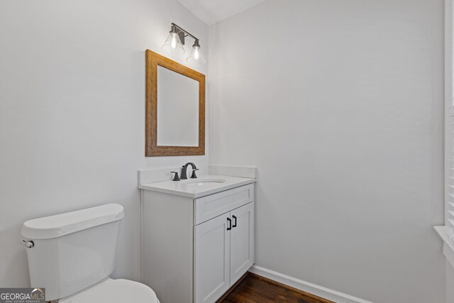bathroom featuring vanity, wood-type flooring, and toilet