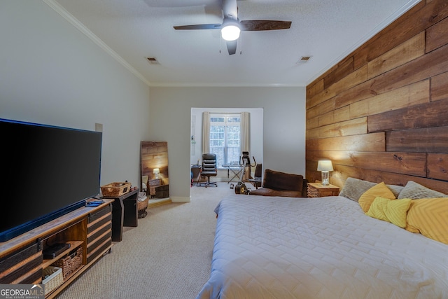 bedroom with light colored carpet, a textured ceiling, ornamental molding, wooden walls, and ceiling fan