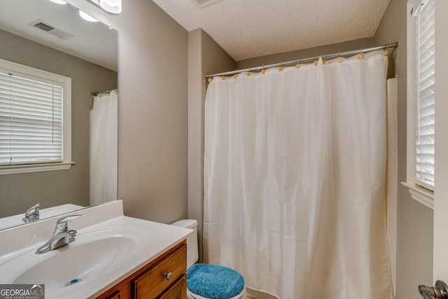 bathroom with vanity, a textured ceiling, and toilet